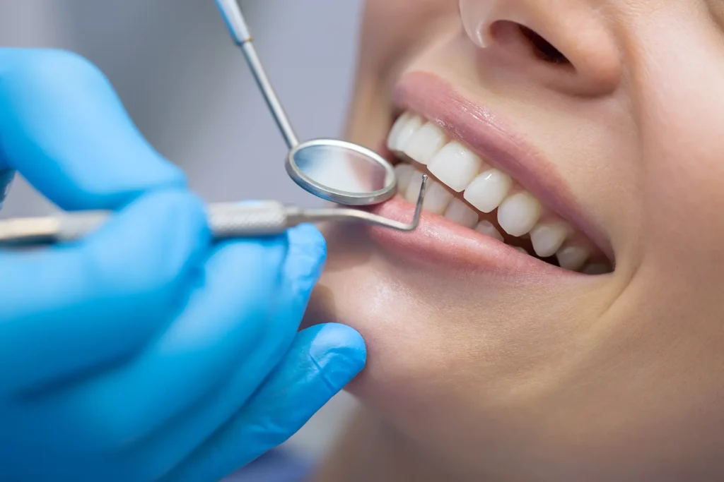 Zahnarzt kontrolliert Zähne einer Patientin (Symbolbild für Prophylaxe)