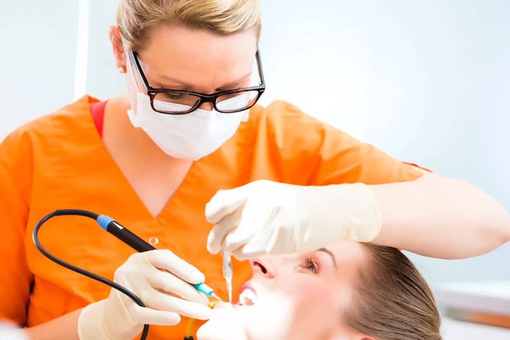 Zahnarztassistentin führt bei einer Patientin eine Professionelle Zahnreinigung (PZR) durch