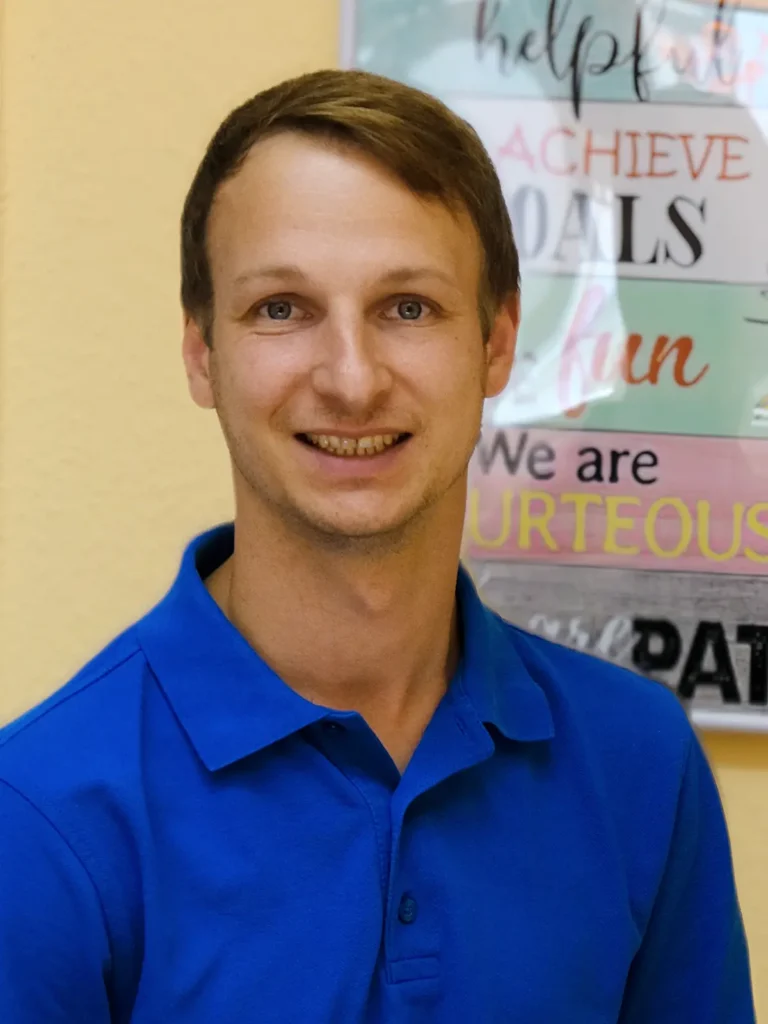 Christian Eck, Inhaber der Zahnarztpraxis Christian Eck: junger Mann mit kurzen dunkelblonden Haaren in blauem Polohemd